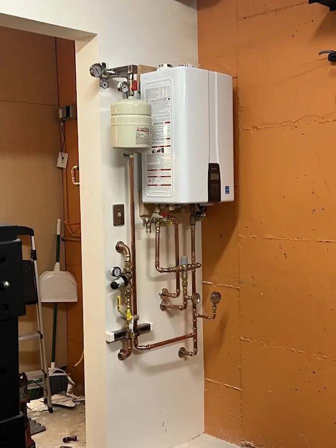 Plumbing technician inspecting water heater connections in Eliot